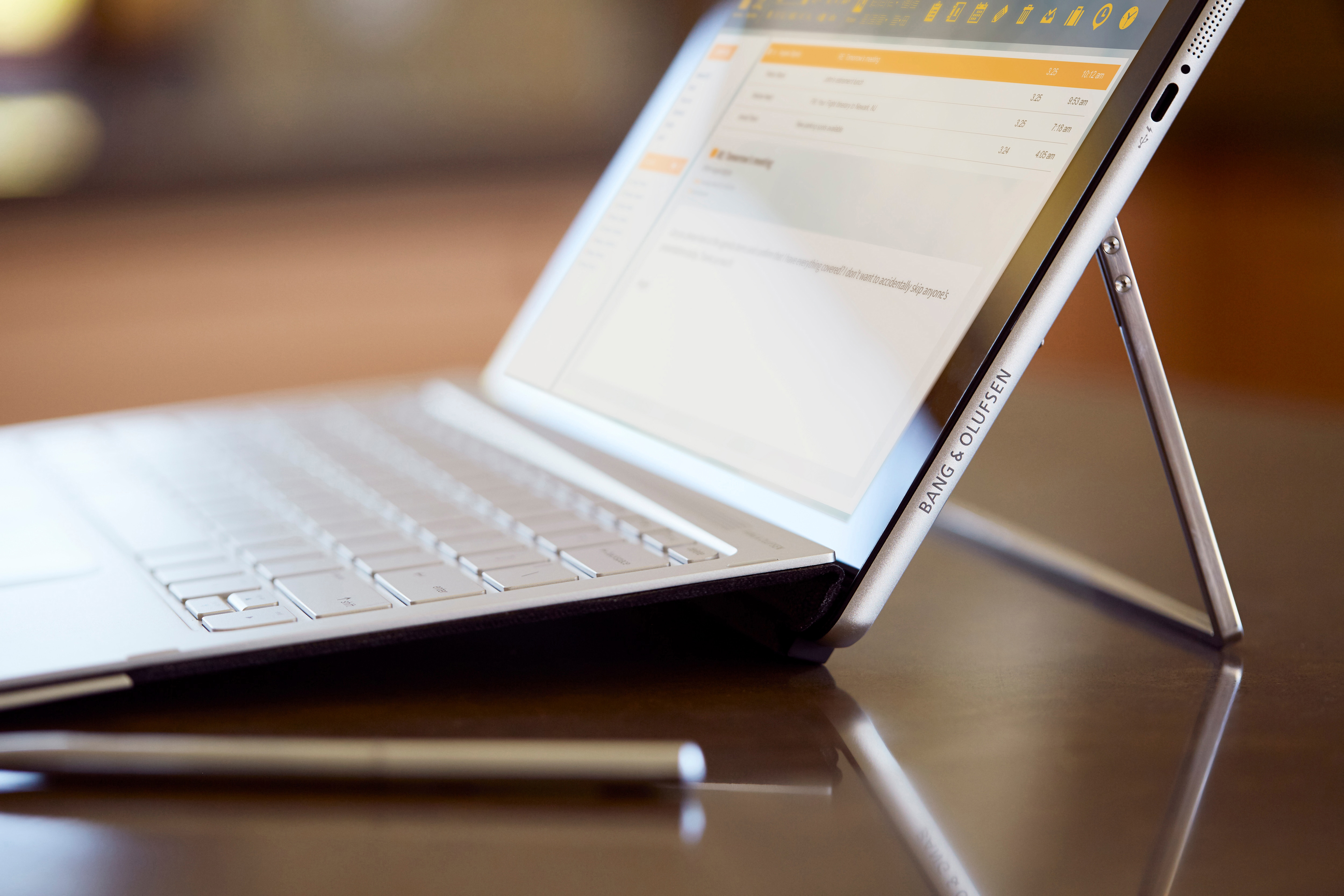 Ein Tablet mit Tastatur und Stift auf einem Tisch, das Bang & Olufsen Logo ist sichtbar.