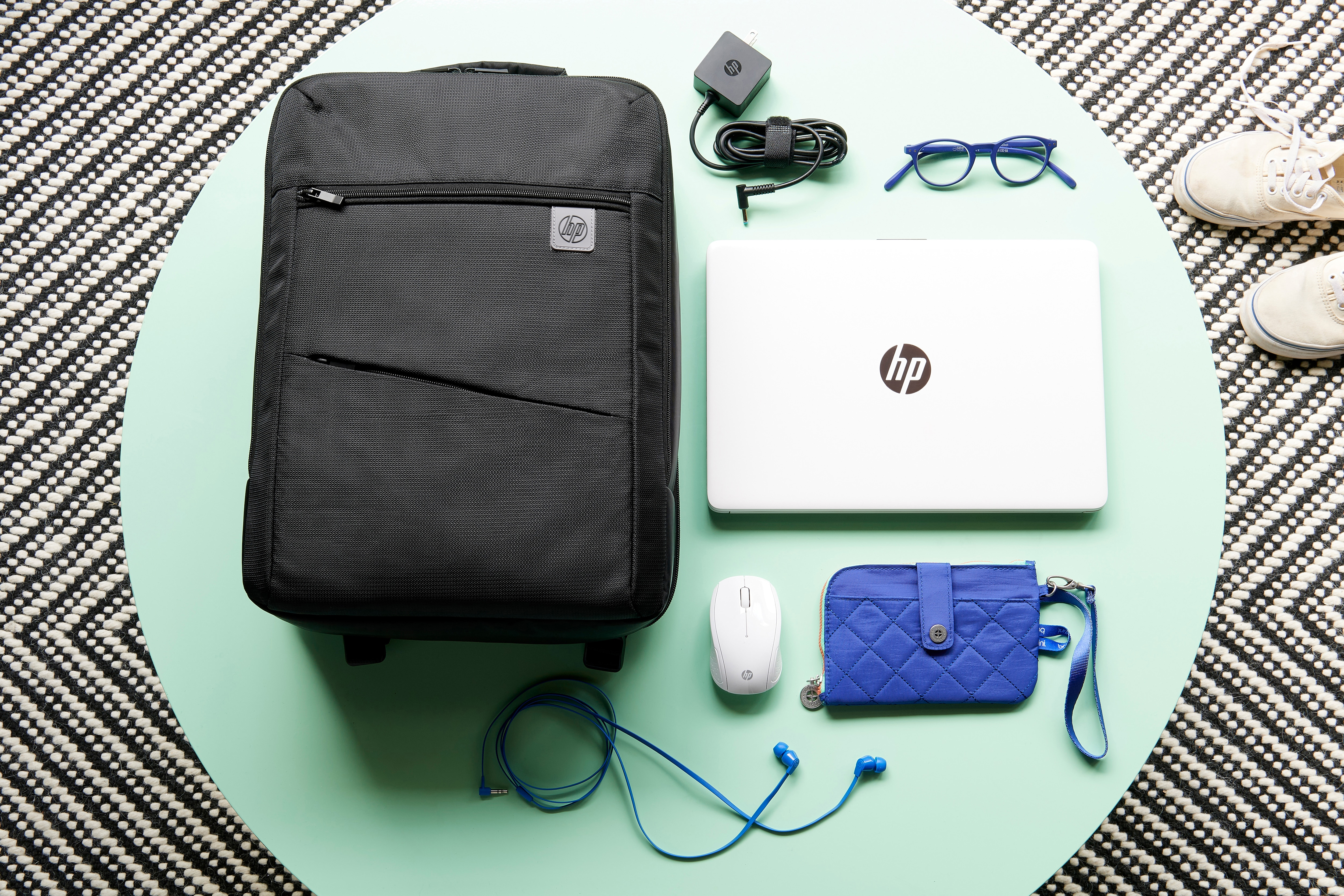 Ein Laptop, eine Tasche und diverses Zubehör auf einem Tisch.