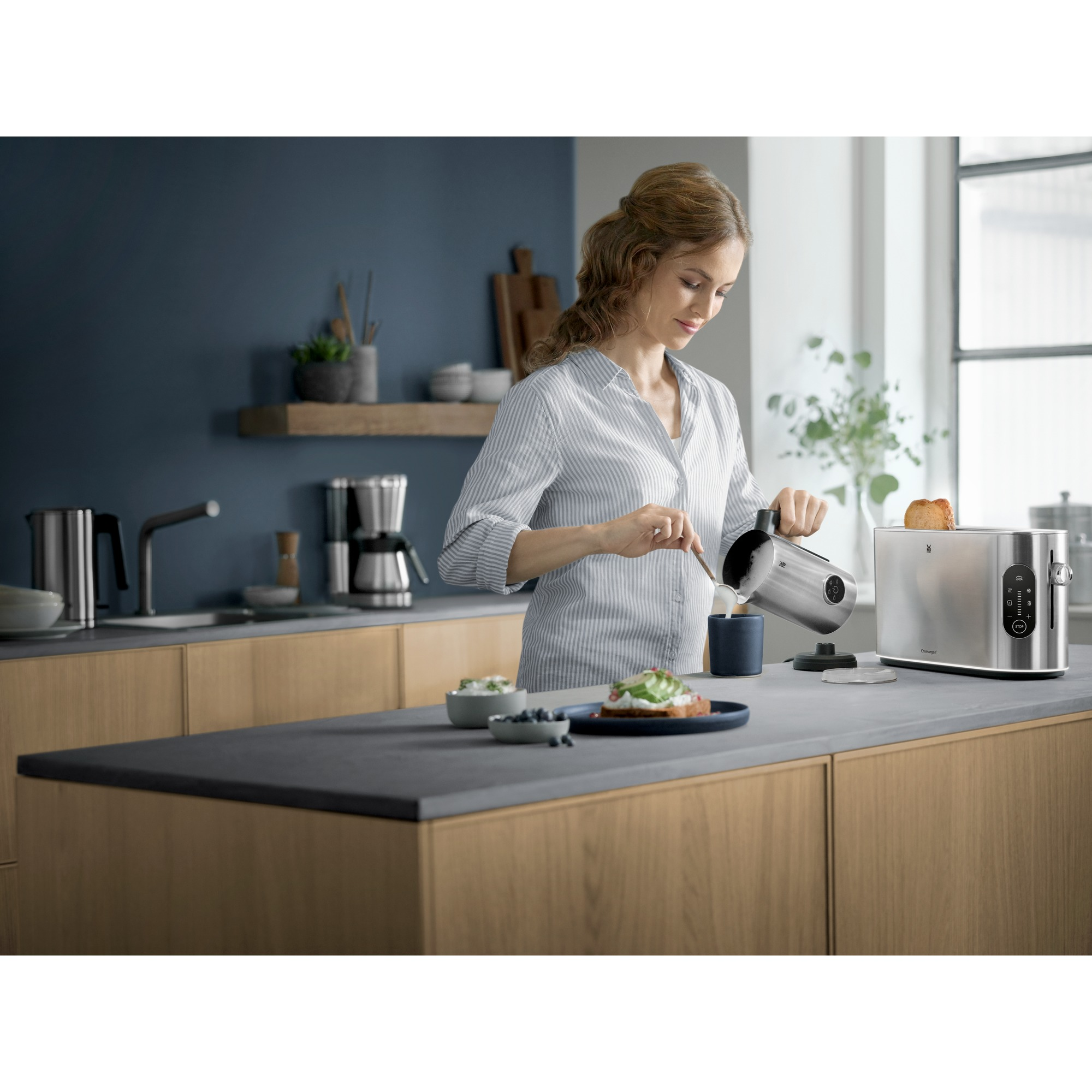 Woman pouring liquid into a cup near a toaster, kitchen background.