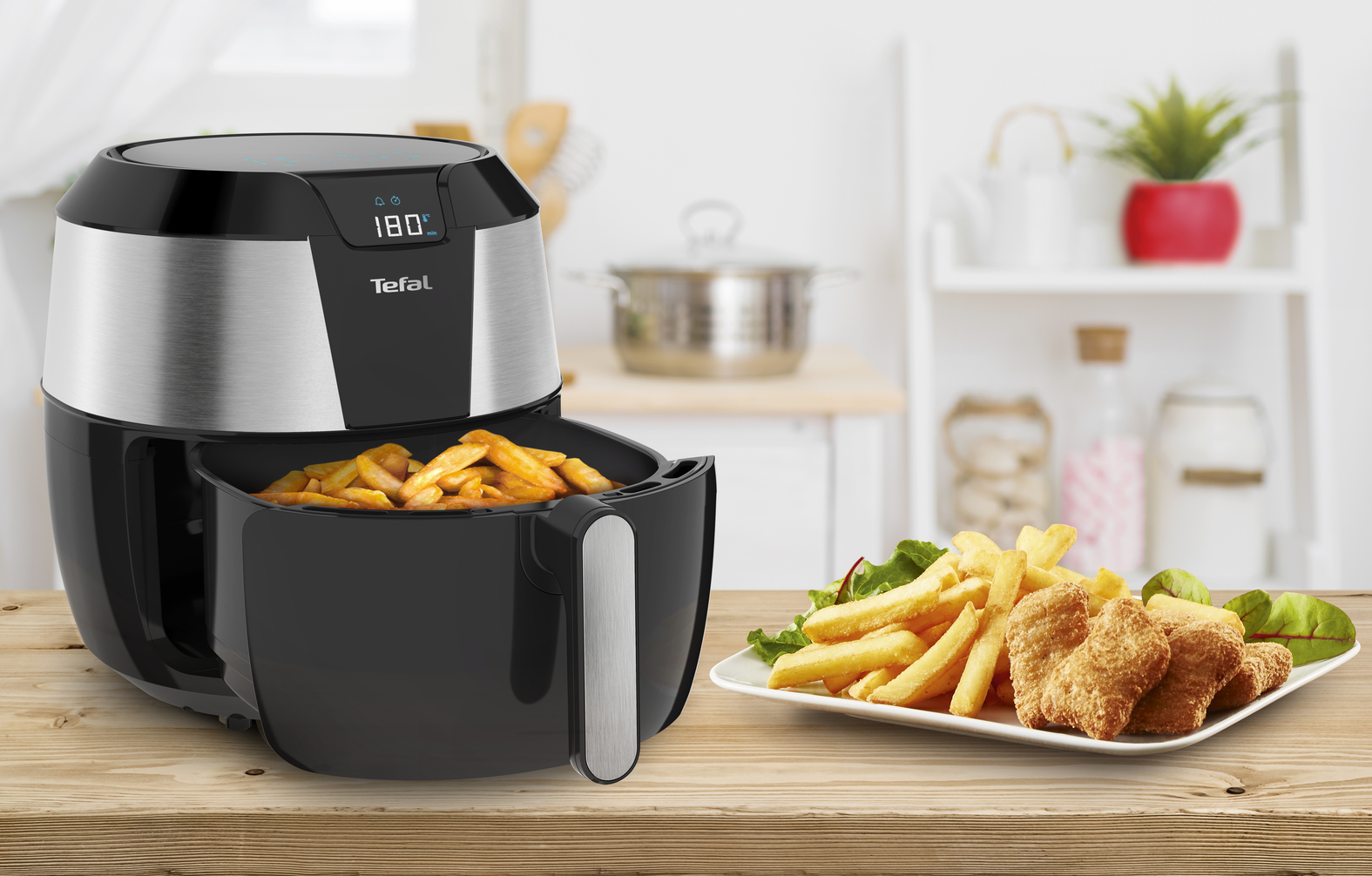 An air fryer with fries and nuggets on a plate, and a kitchen background.