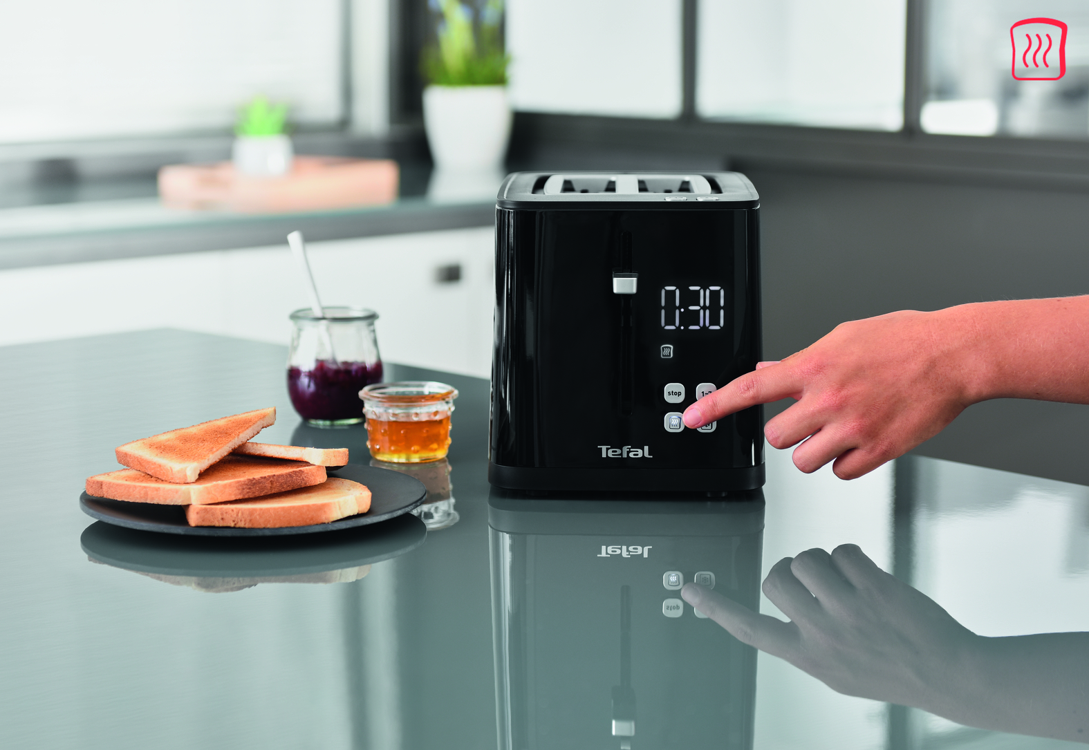 Zwarte broodrooster met digitaal display, hand drukt op knop, geroosterd brood.