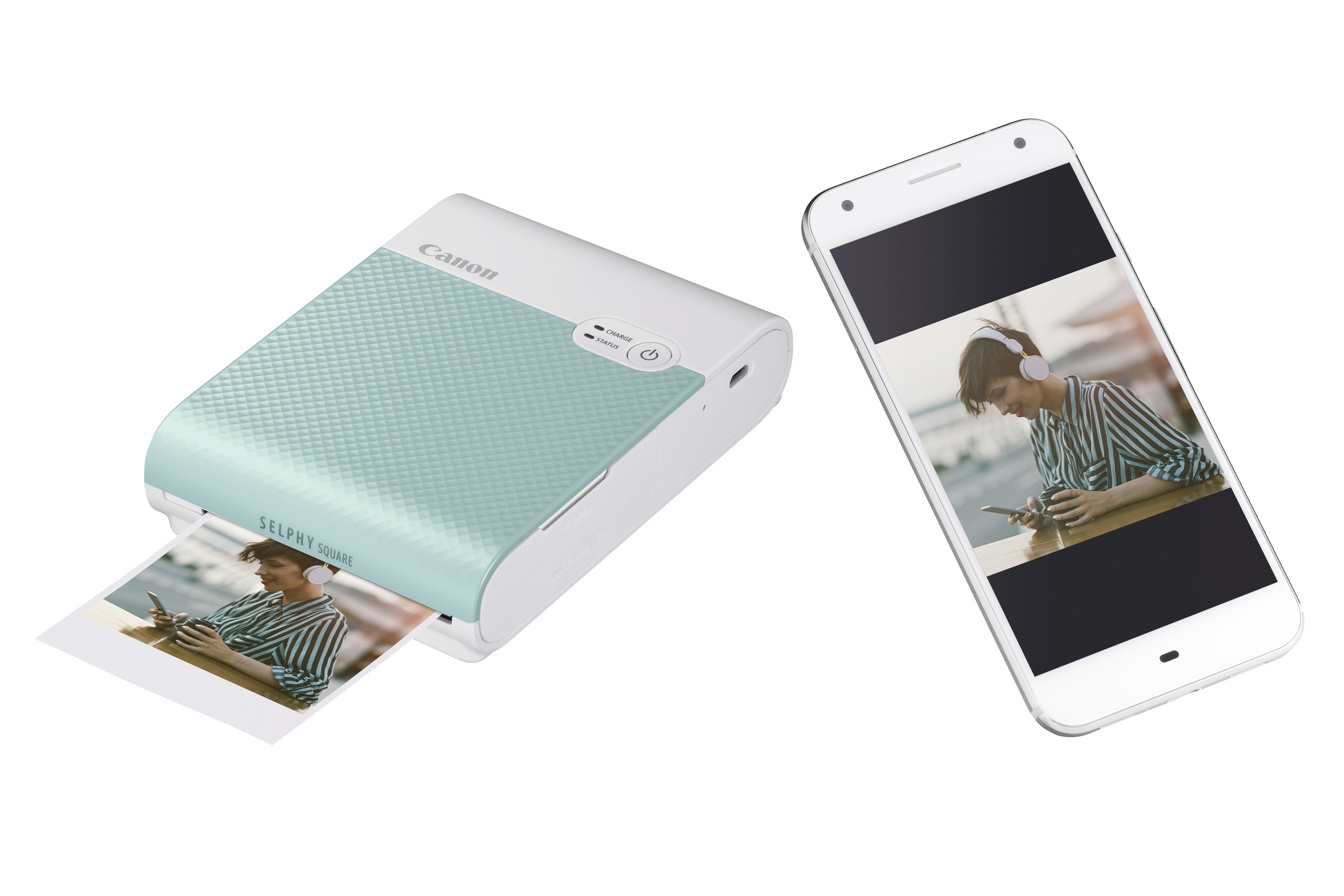 A Canon Selphy Square printer printing a photo, with a smartphone showing a photo.