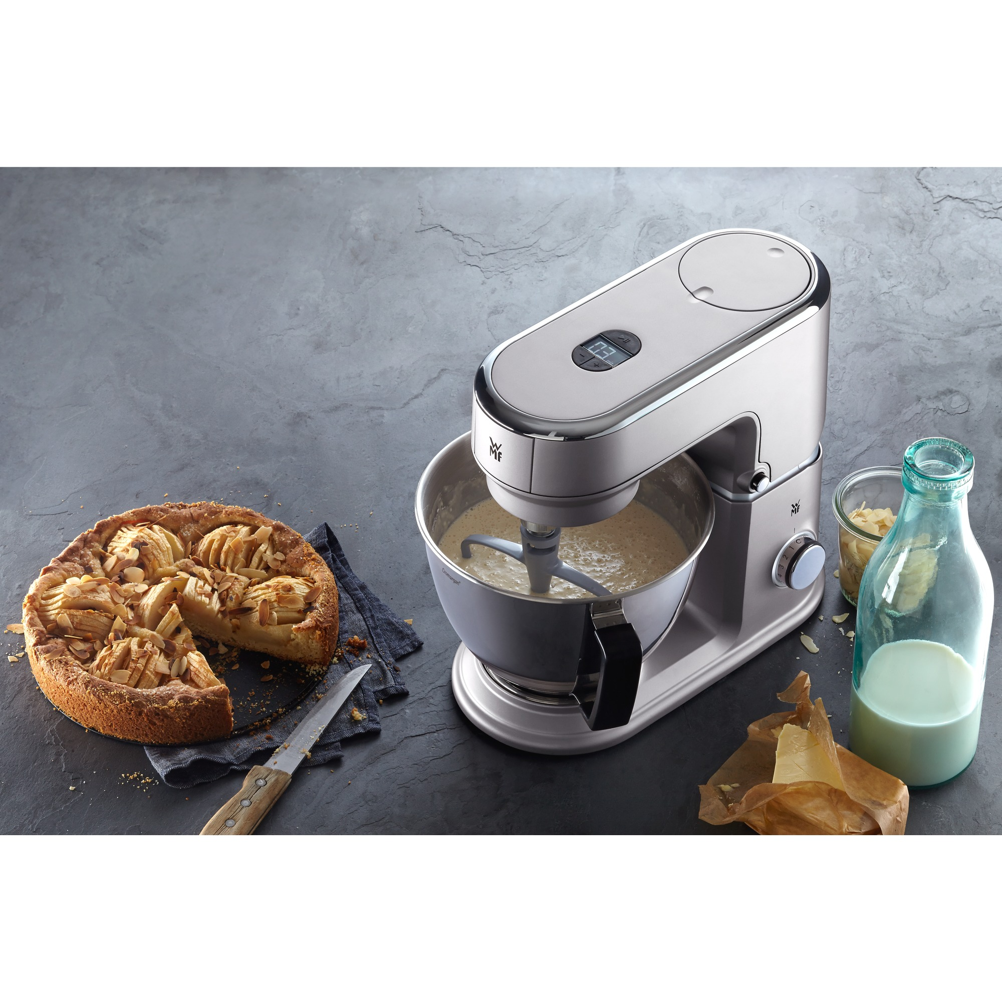 Kitchen appliance, a silver stand mixer with a cake and ingredients.