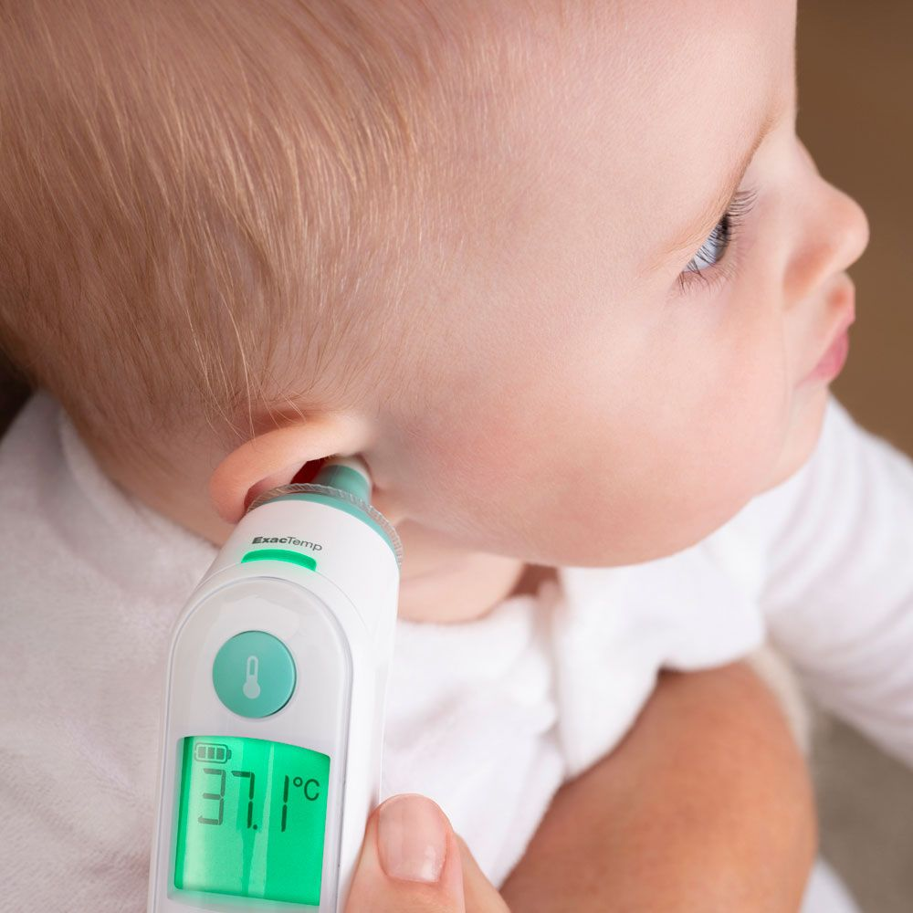 Une personne utilise un thermomètre numérique pour mesurer la température de l'oreille d'un bébé. L'écran affiche la température.