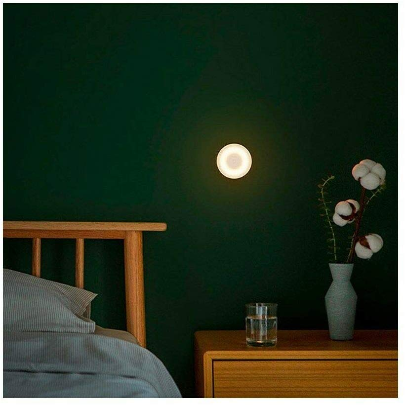 Una escena de dormitorio con una lámpara, una cama y flores.