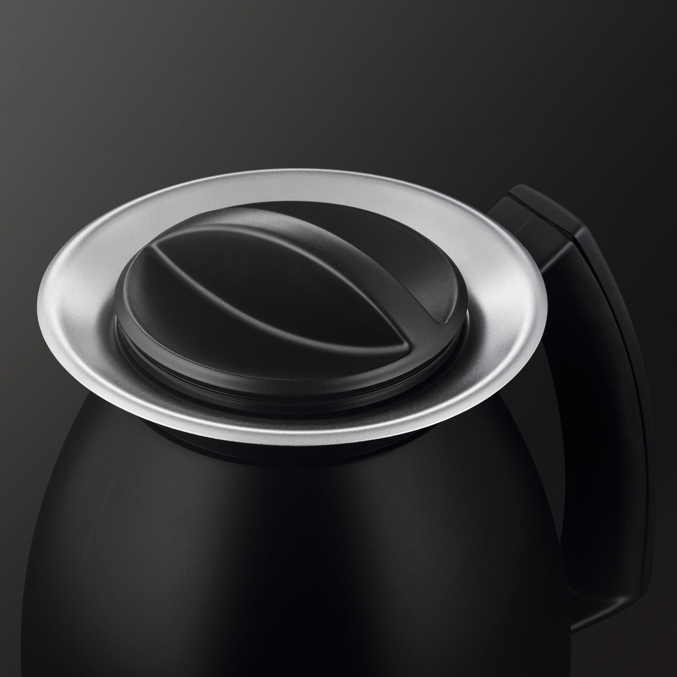 Schwarzer Kaffeekannendeckel mit einem silbernen Ring am Rand.