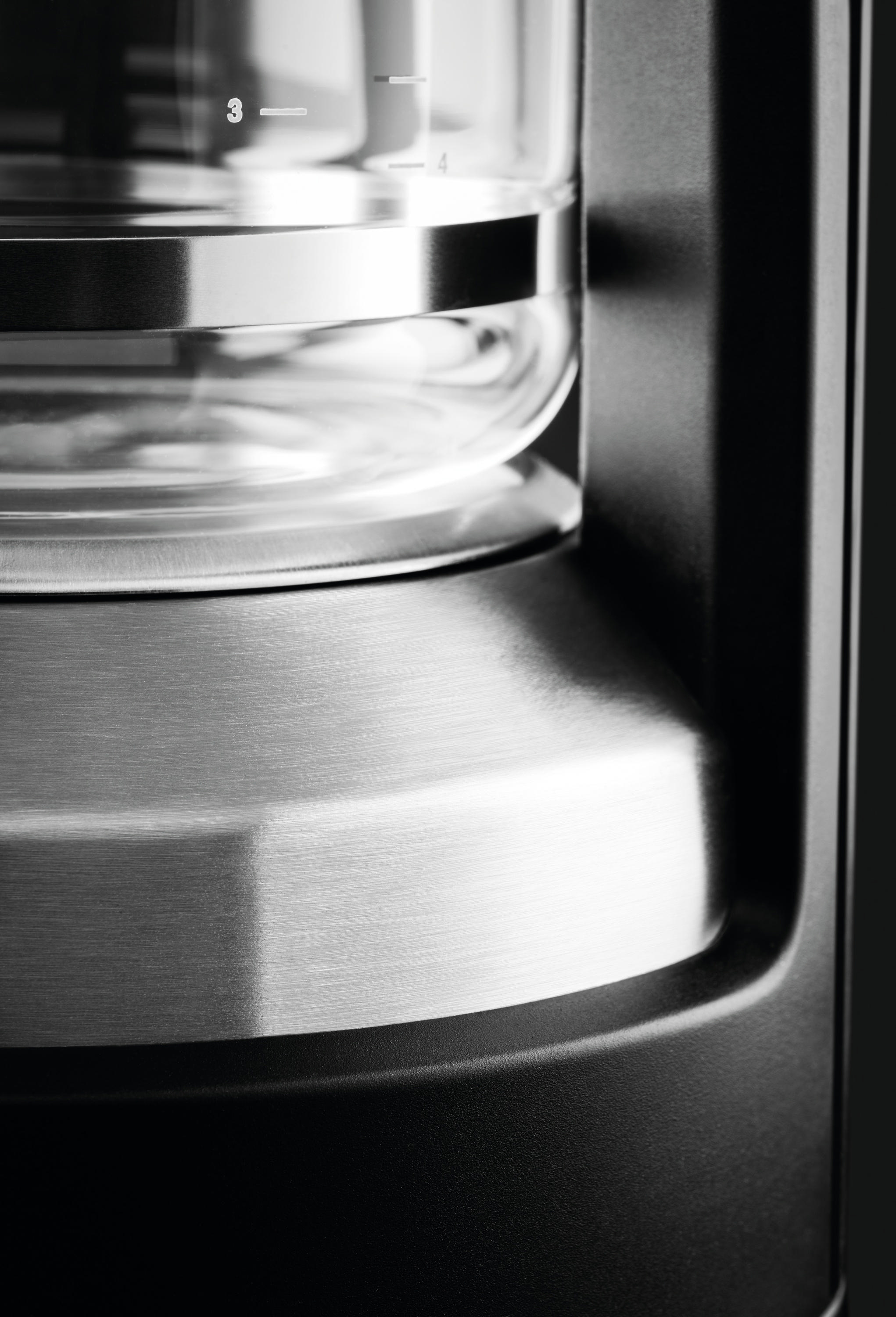 Nahaufnahme einer Kaffeemaschine mit Glaskanne und Edelstahlbasis.