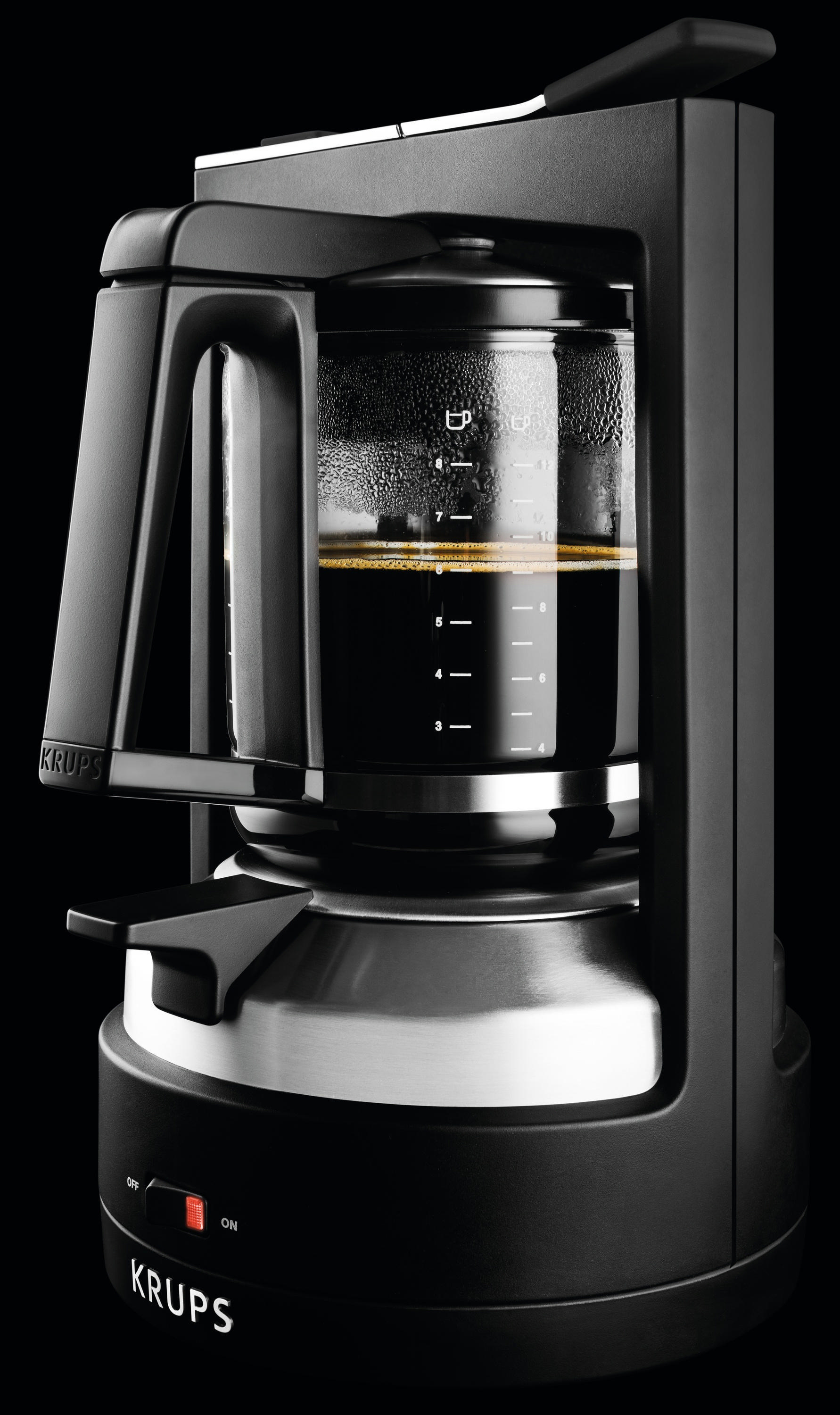 Eine schwarze Krups Kaffeemaschine mit einer Glaskaraffe, die mit Kaffee gefüllt ist.