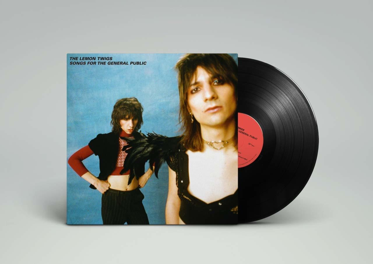 Albumcover mit zwei Personen. Eine Schallplatte liegt neben dem Cover auf hellem Grund.