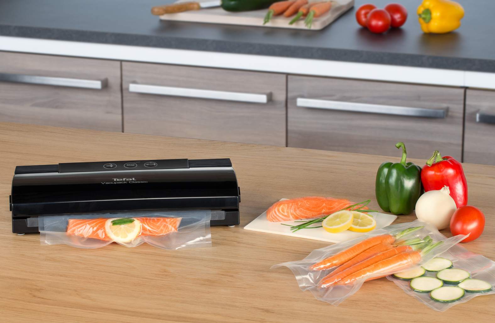 Eten op tafel: vacuüm sealer, zalm, groenten en fruit. Houten keuken.