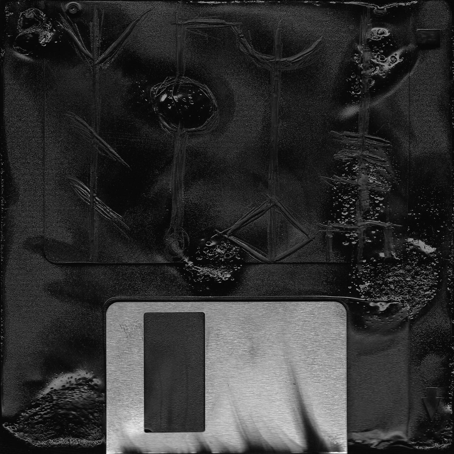 Schwarze Diskette mit silbernem Etikett und abstrakten Markierungen. Dunkler Hintergrund.