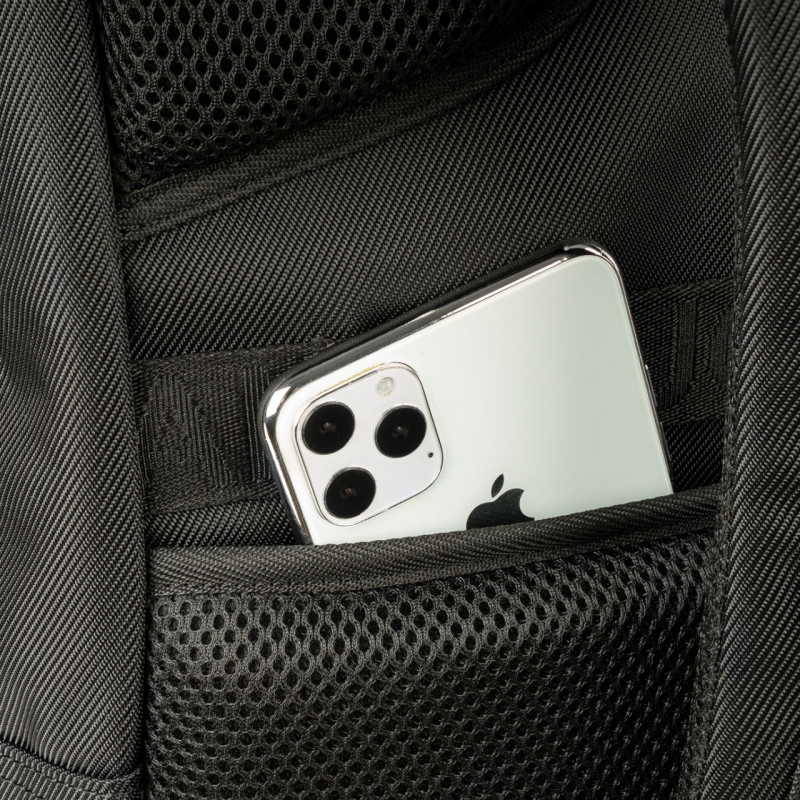 Un smartphone est placé dans une poche de sac à dos, partiellement visible.