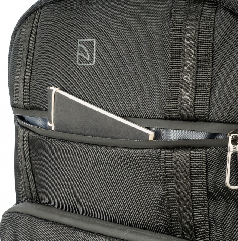 Sac à dos noir avec un petit carnet visible dans la poche avant.