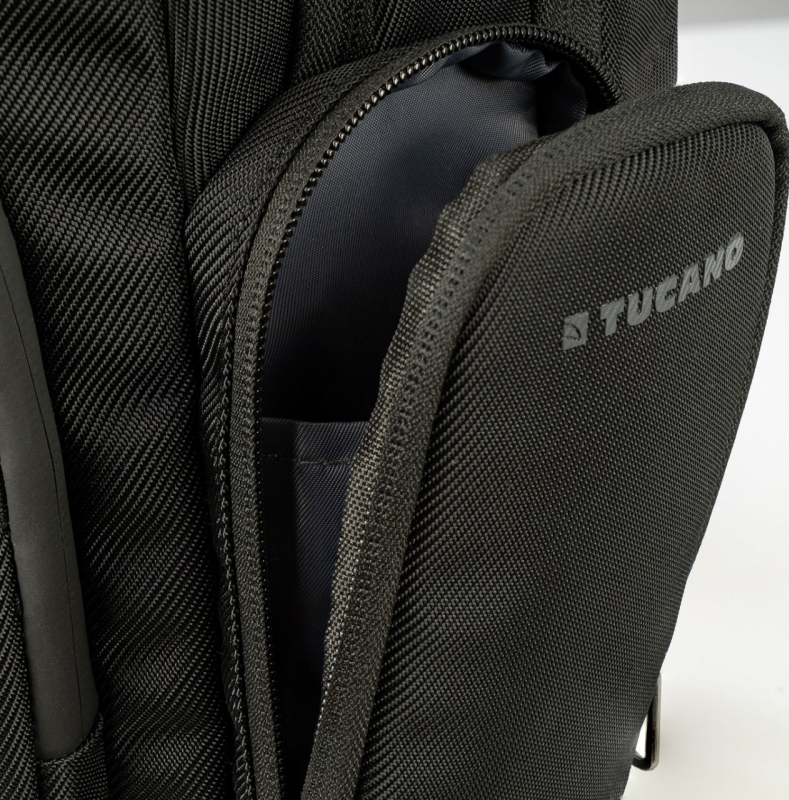 Sac à dos noir avec une poche latérale ouverte montrant l'intérieur.