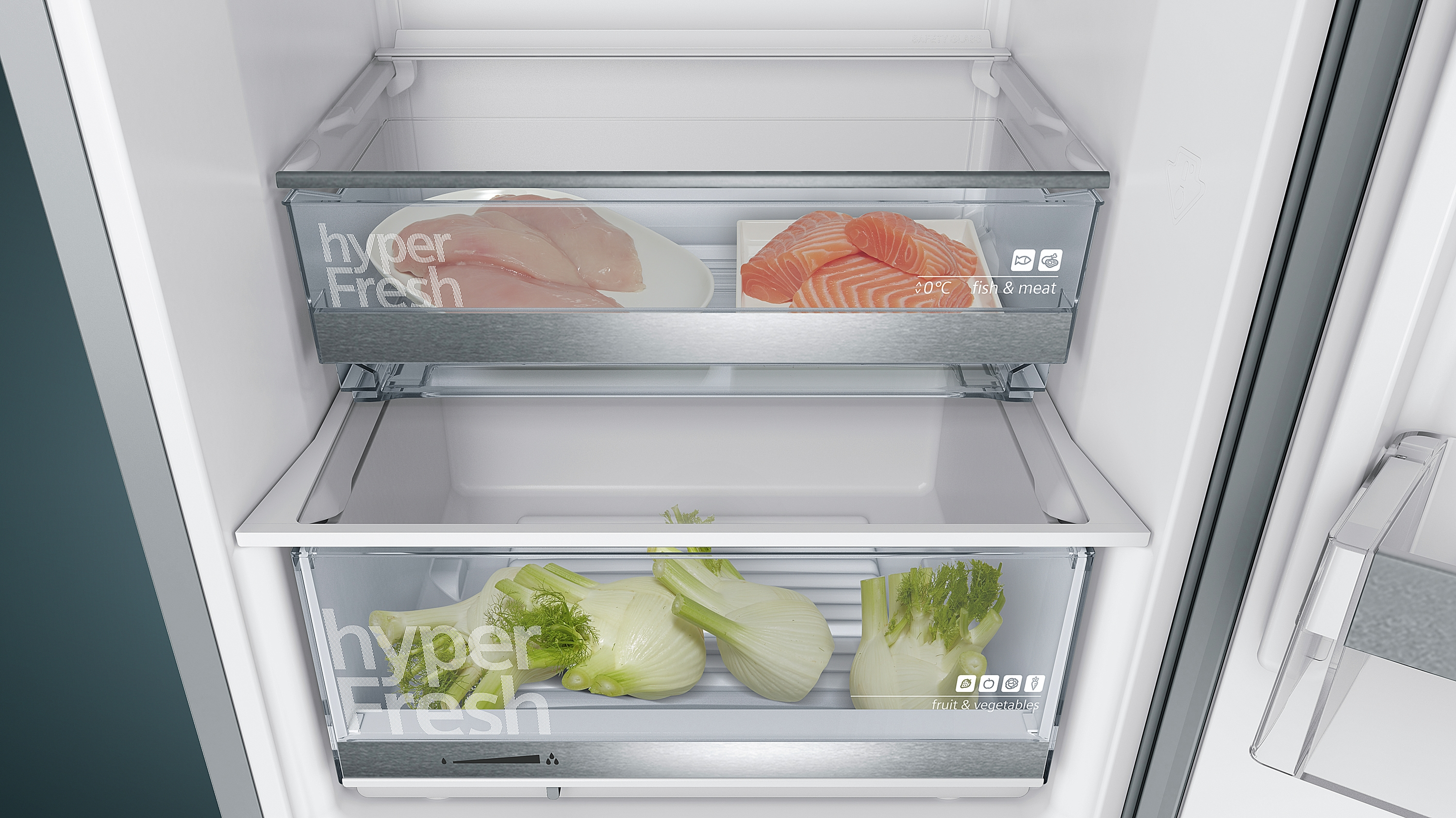 Im Inneren eines Kühlschranks, der zwei Schubladen mit frischen Lebensmitteln zeigt: Fisch, Fleisch und Gemüse.