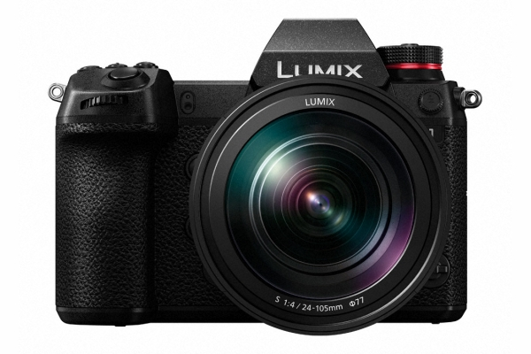 Schwarze Digitalkamera mit Objektiv, Lumix-Etikett, Vorderansicht. Weißer Hintergrund.
