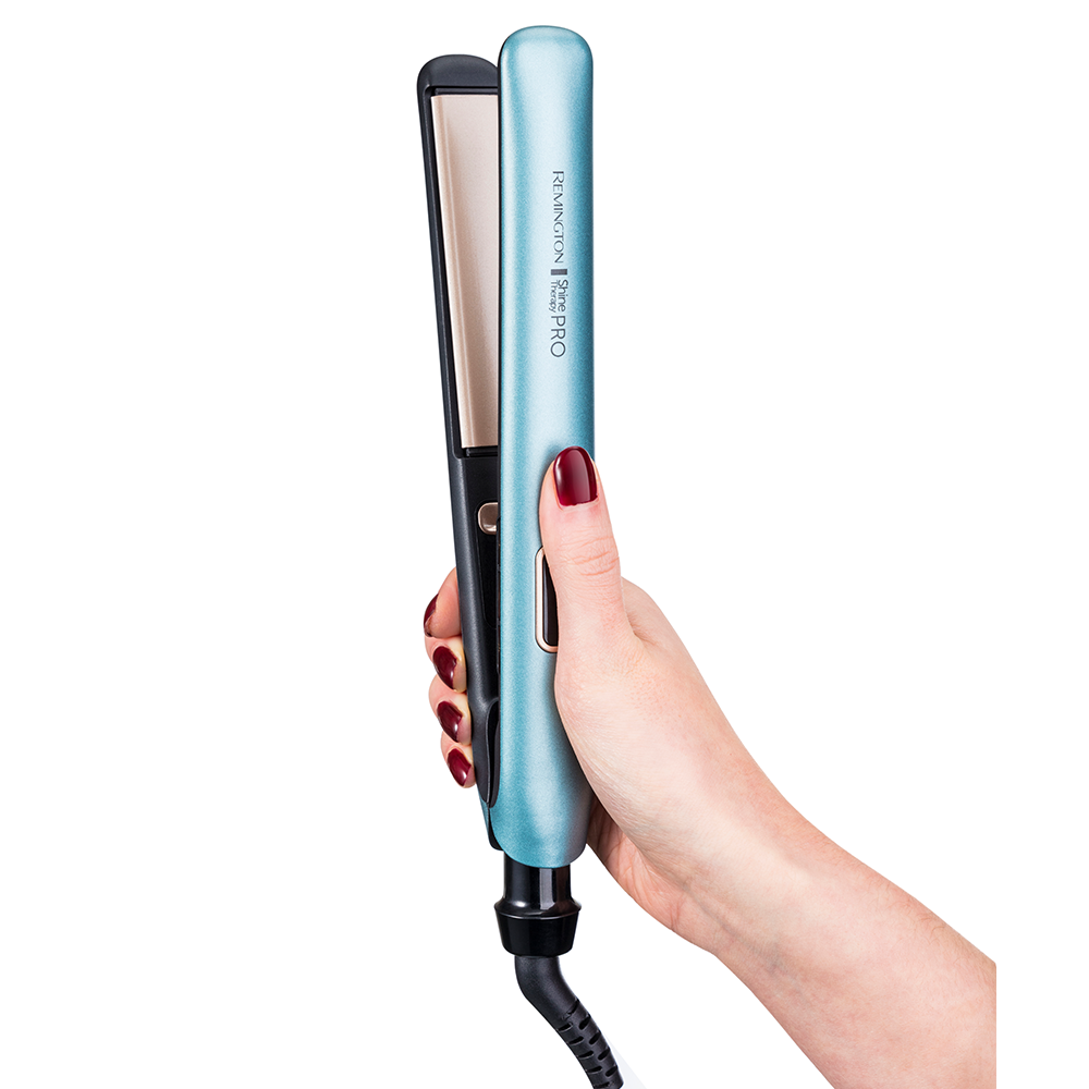 Een hand van een vrouw die een lichtblauwe Remington stijltang vasthoudt. De stijltang is zwart en goud.