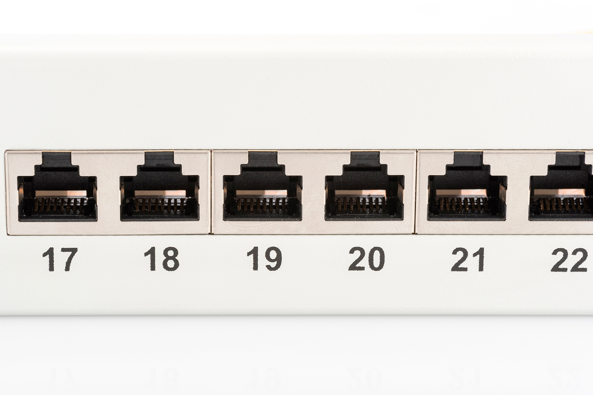 Nahaufnahme eines weißen Netzwerk-Patchfelds mit nummerierten Ports 17-22.