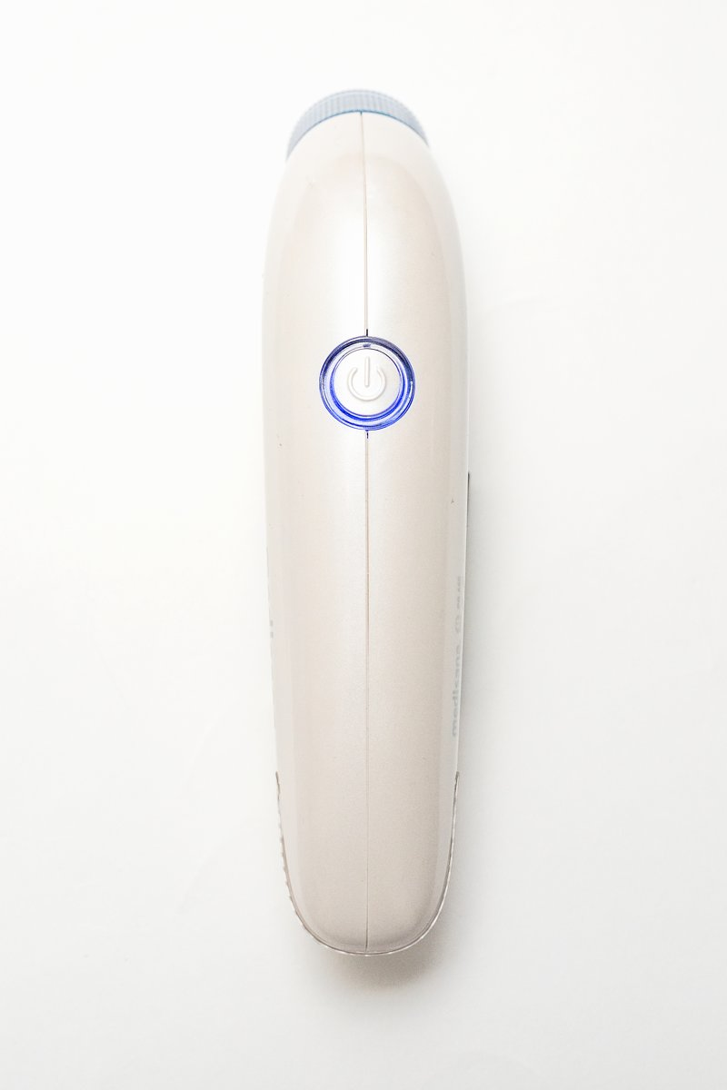 White and beige electric lint remover with a blue power button. White background.