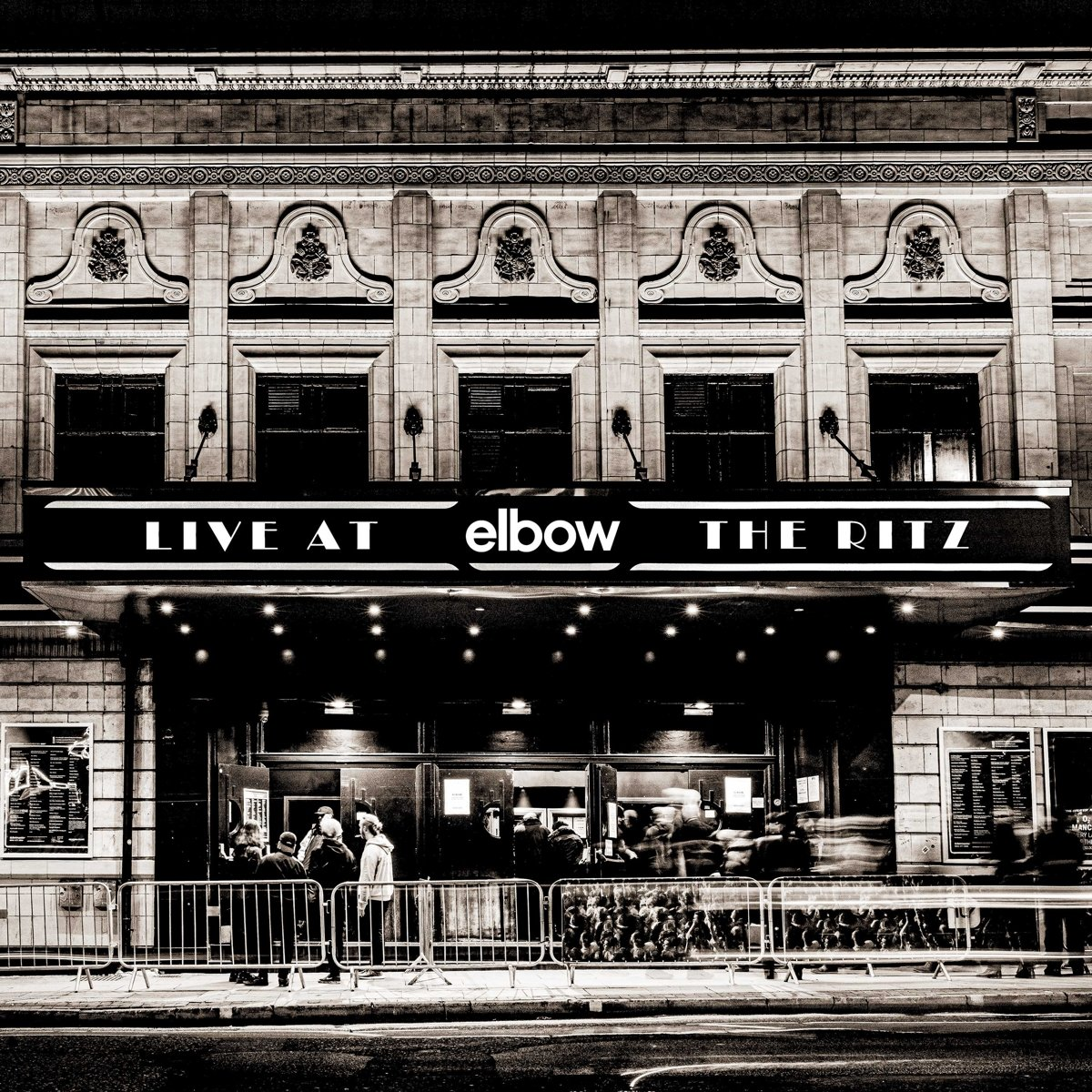 Une photo en noir et blanc d'un bâtiment avec une enseigne « LIVE AT ELBOW THE RITZ ».