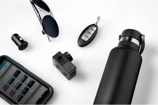 Diverse items op een wit oppervlak, waaronder een telefoon, camera.