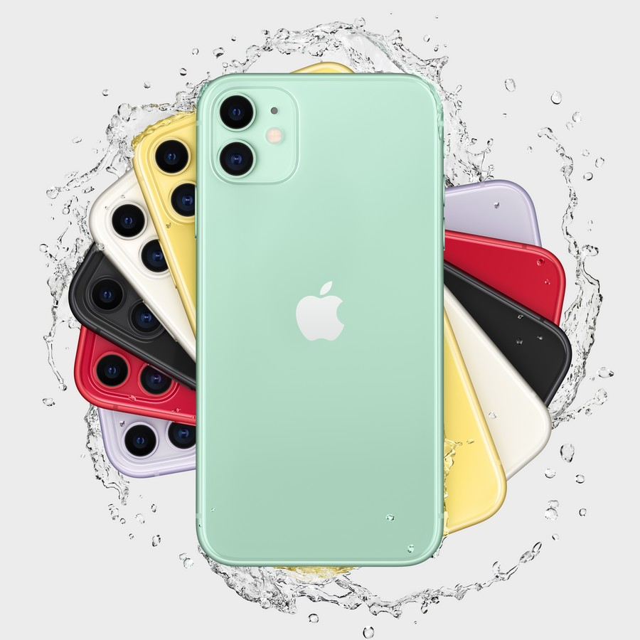 Una variedad de iPhones coloridos, incluyendo verde, amarillo, negro y rojo, rodeados de salpicaduras de agua.