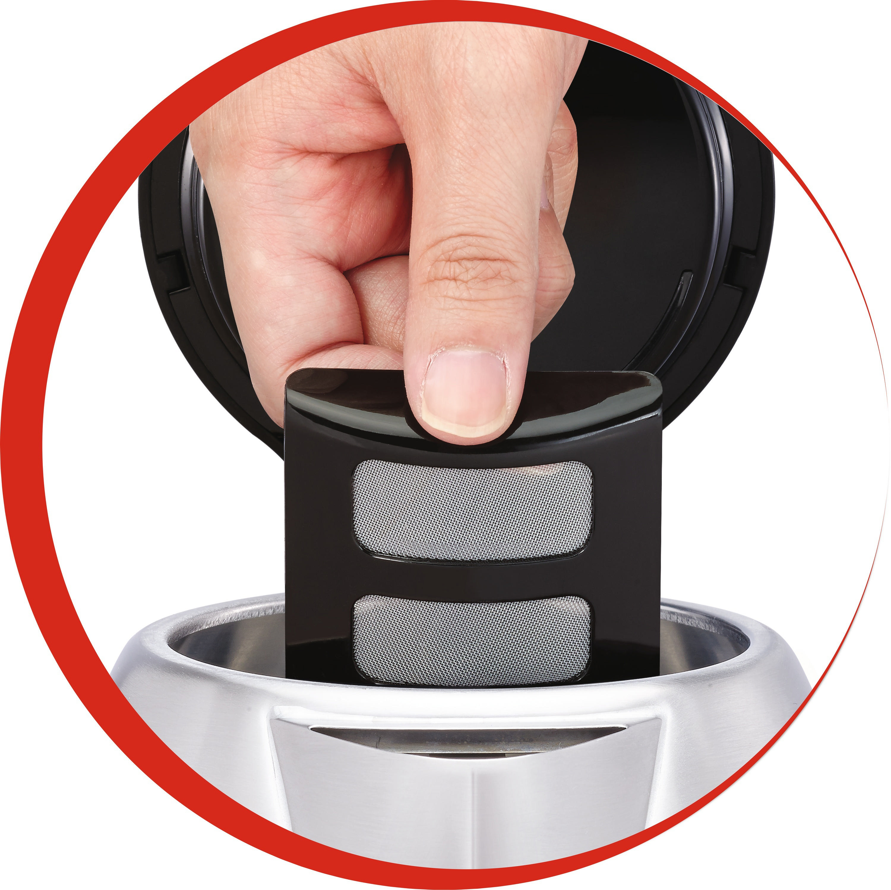 Eine Hand, die einen Filter in eine Kaffeemaschine einsetzt. Der Filter ist schwarz mit einem silbernen Netz.