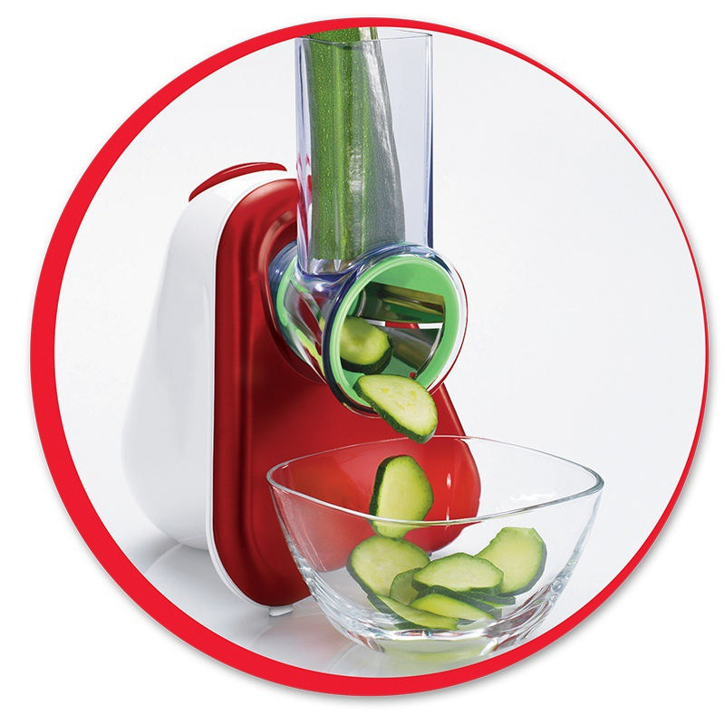 Ein rot-weißes Küchengerät, das Zucchini in eine Schüssel schneidet.