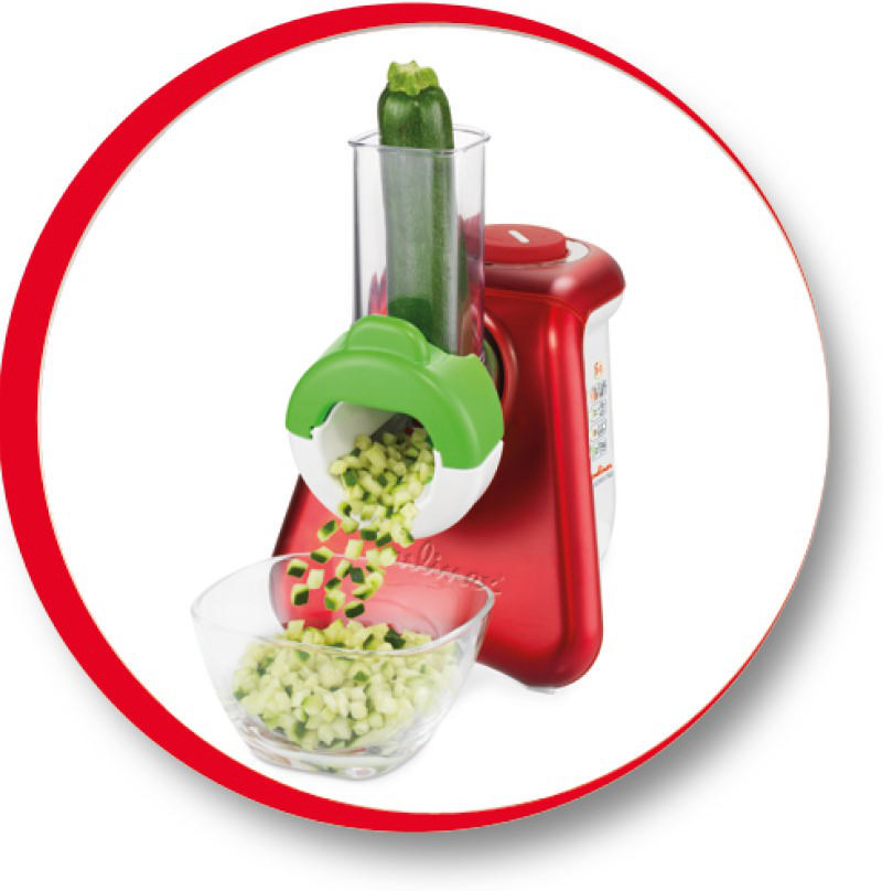 Rote Küchenmaschine mit Zucchini, die verarbeitet wird, und eine Schüssel mit gewürfelten Zucchini.