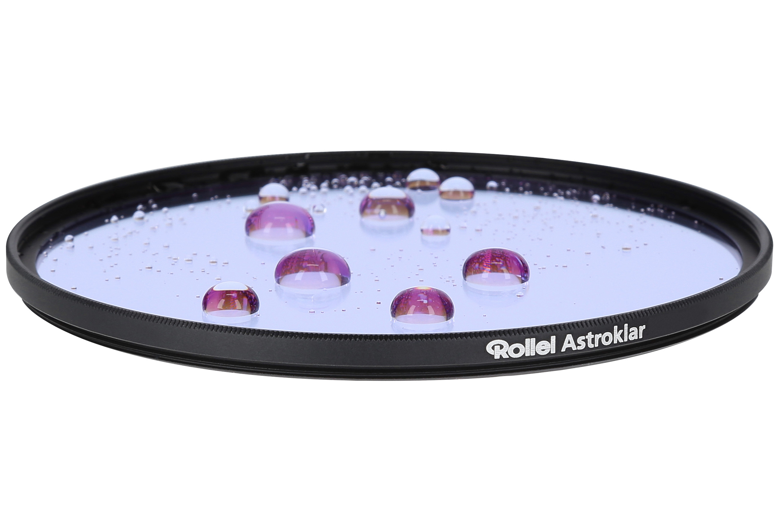A circular filter with water droplets. The filter is black, with a blue tint. Droplets are clear with a pink hue.