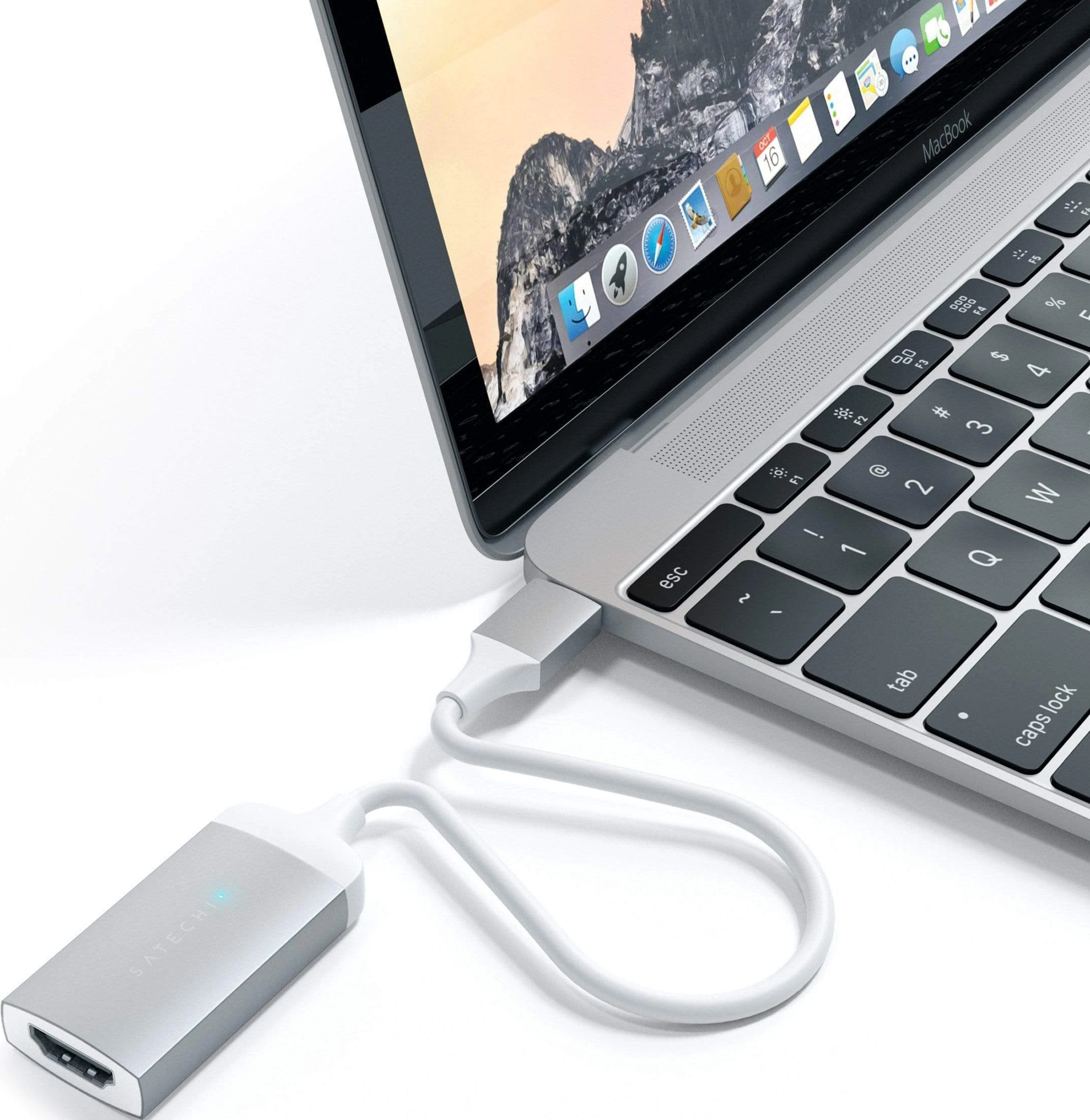 Ein MacBook, verbunden mit einem silbernen HDMI-Adapter, mit weißem Kabel.