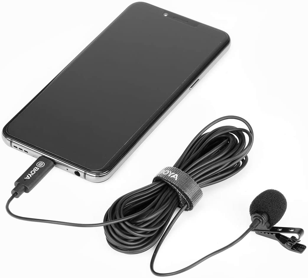 Smartphone connecté à un micro-cravate. Le câble du micro est noir et enroulé.