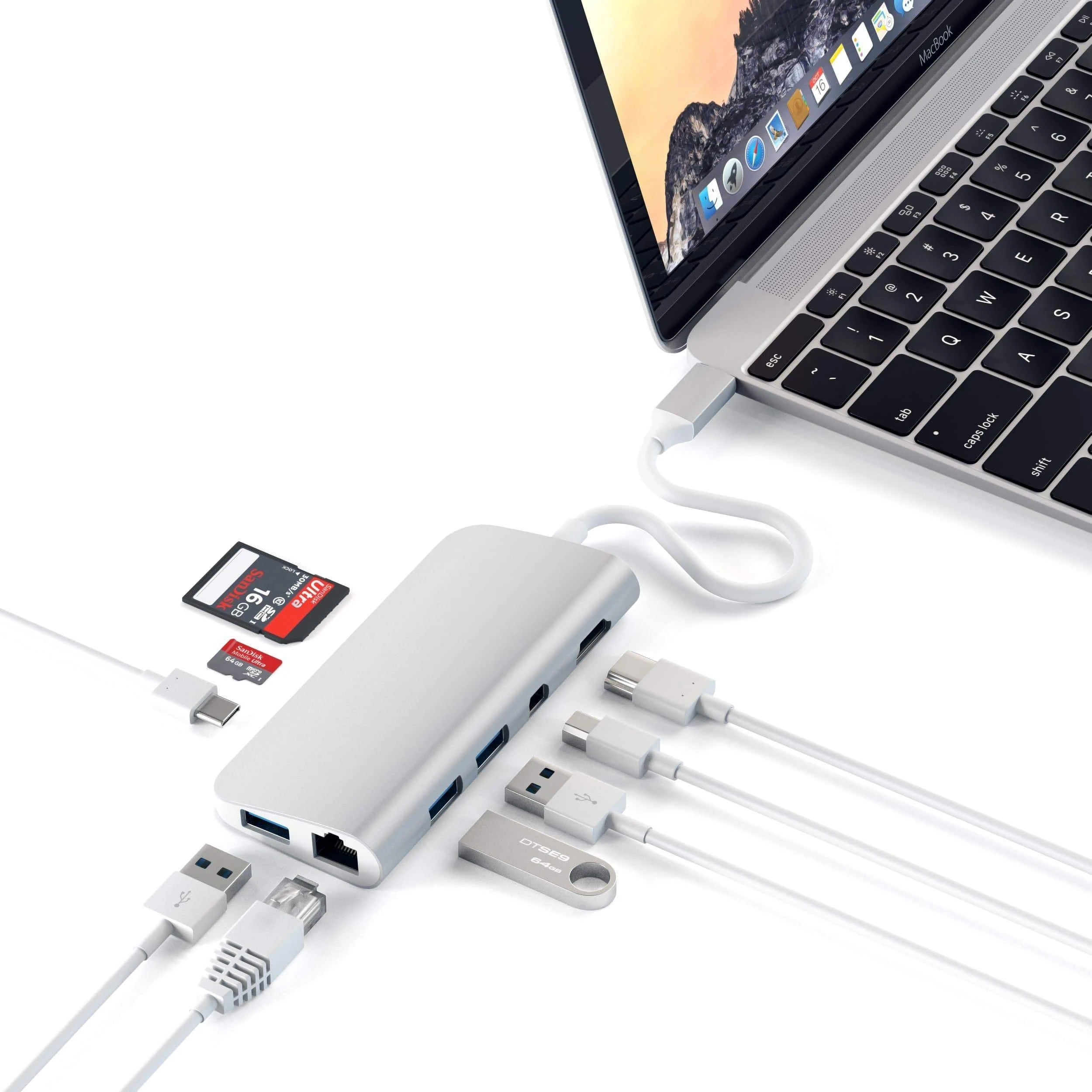 Un laptop collegato a un hub argentato con vari dispositivi e cavi collegati.