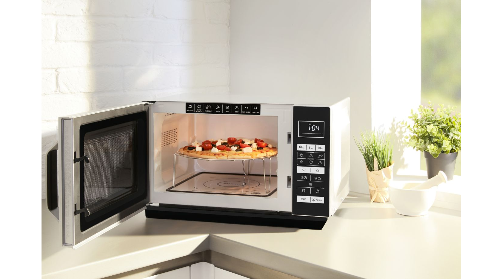 Four à micro-ondes avec la porte ouverte, montrant une pizza sur une grille. Le panneau de contrôle est à droite.