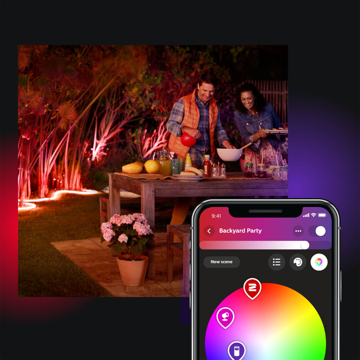 People are preparing food at a table in a backyard, illuminated by colorful lights.