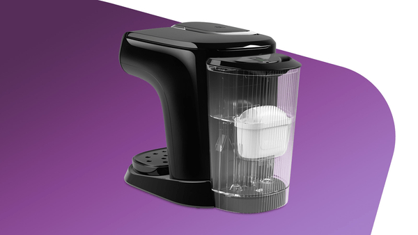 Schwarze Kaffeemaschine mit transparentem Wassertank und weißem Filter. Lila Hintergrund.