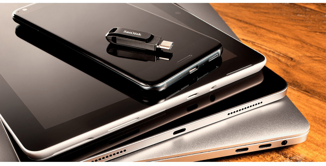 Une clé USB sur un téléphone, une tablette et un ordinateur portable.