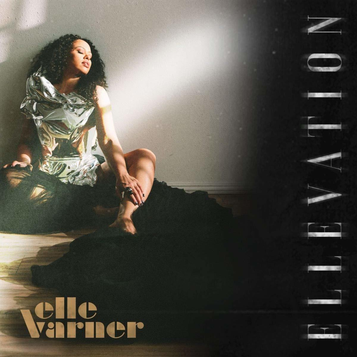 Albumcover von Elle Varner, die auf einem schwarzen Stoff sitzt und sich an eine Wand lehnt mit dem Titel 'Elevation'.