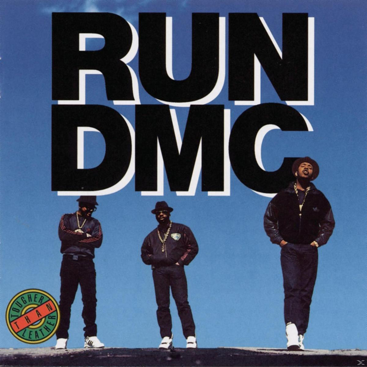 Run DMC steht, drei Figuren vor blauem Himmel. Albumcover sagt 'Run DMC' und 'Tougher Than Leather'.