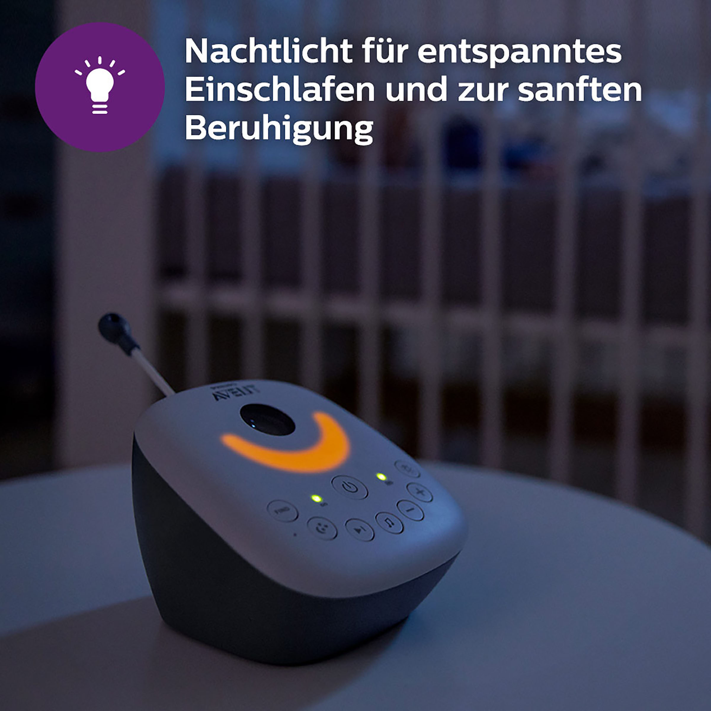 Ein Babyphone auf einem Tisch mit orangefarbenem Licht, mit deutschem Text und einem Glühbirnensymbol.