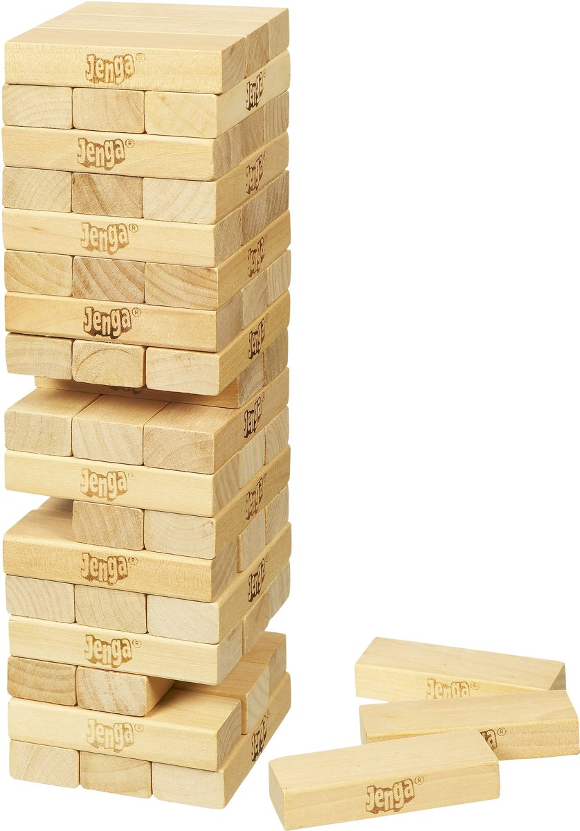 A Jenga game tower of wooden blocks standing on white surface, with some blocks beside.