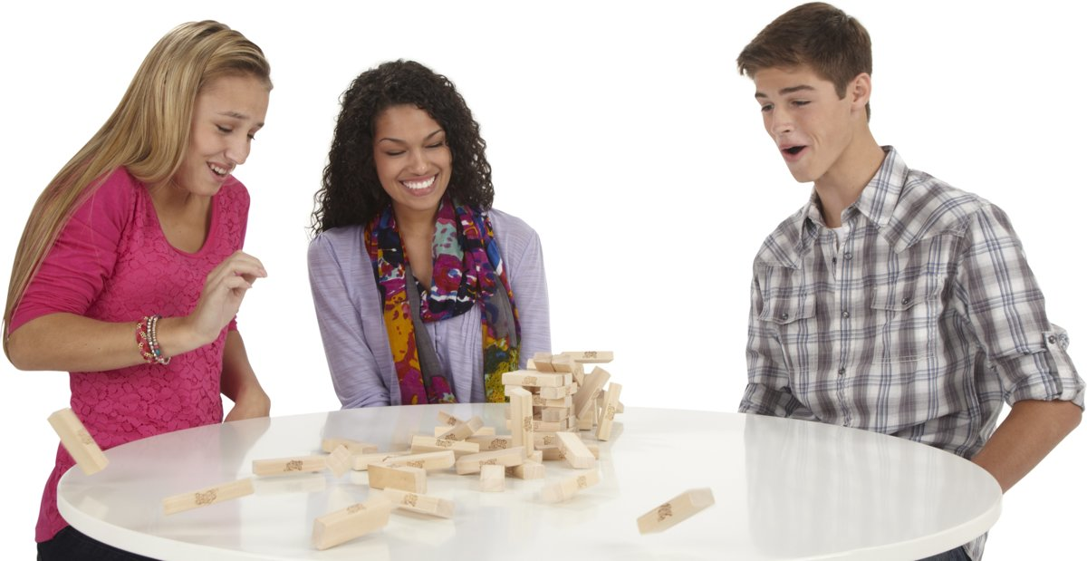 Three people are playing Jenga. Wooden blocks are falling off the tower.