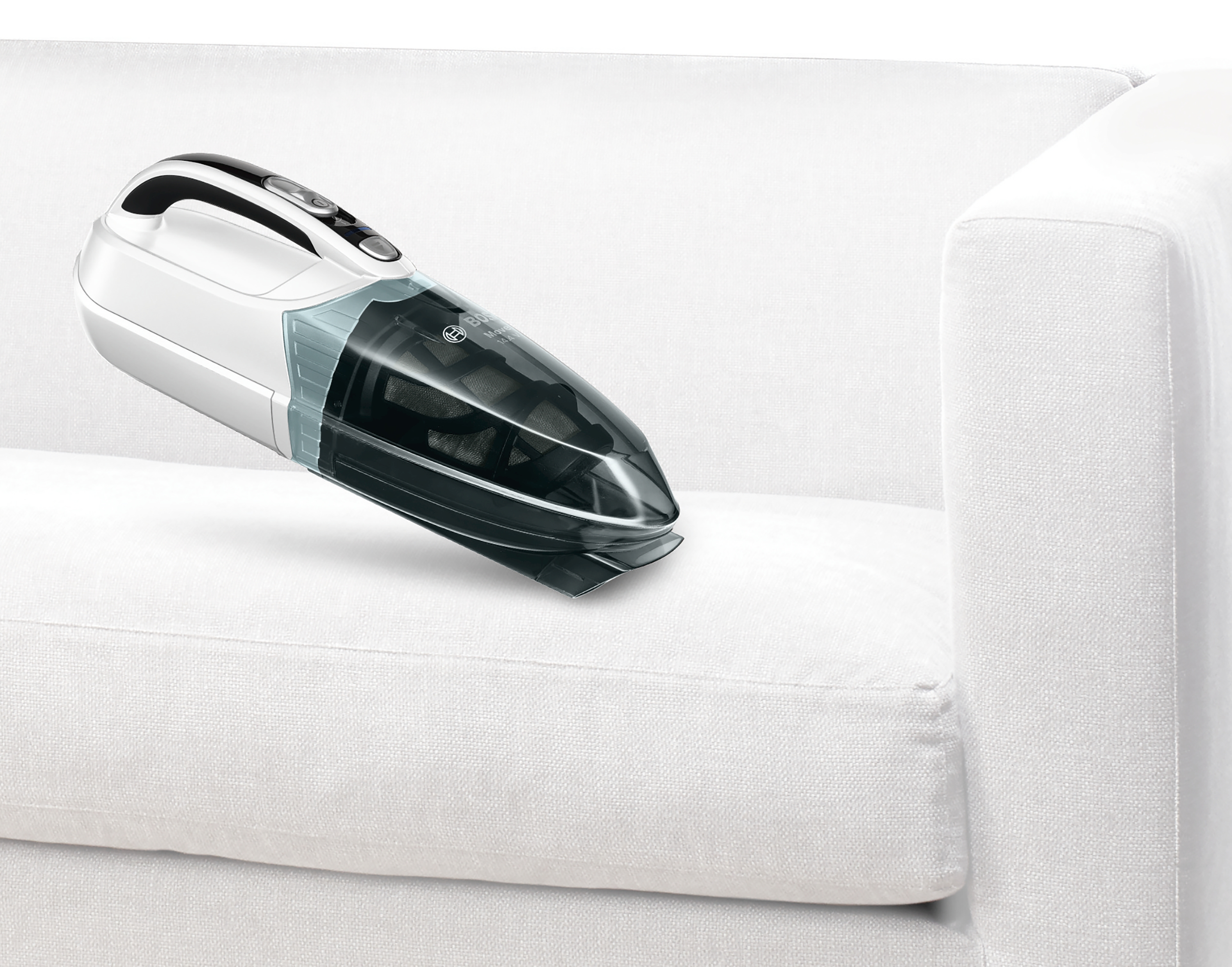 Ein weißer Handstaubsauger reinigt ein weißes Sofa, isoliert auf weißem Hintergrund.