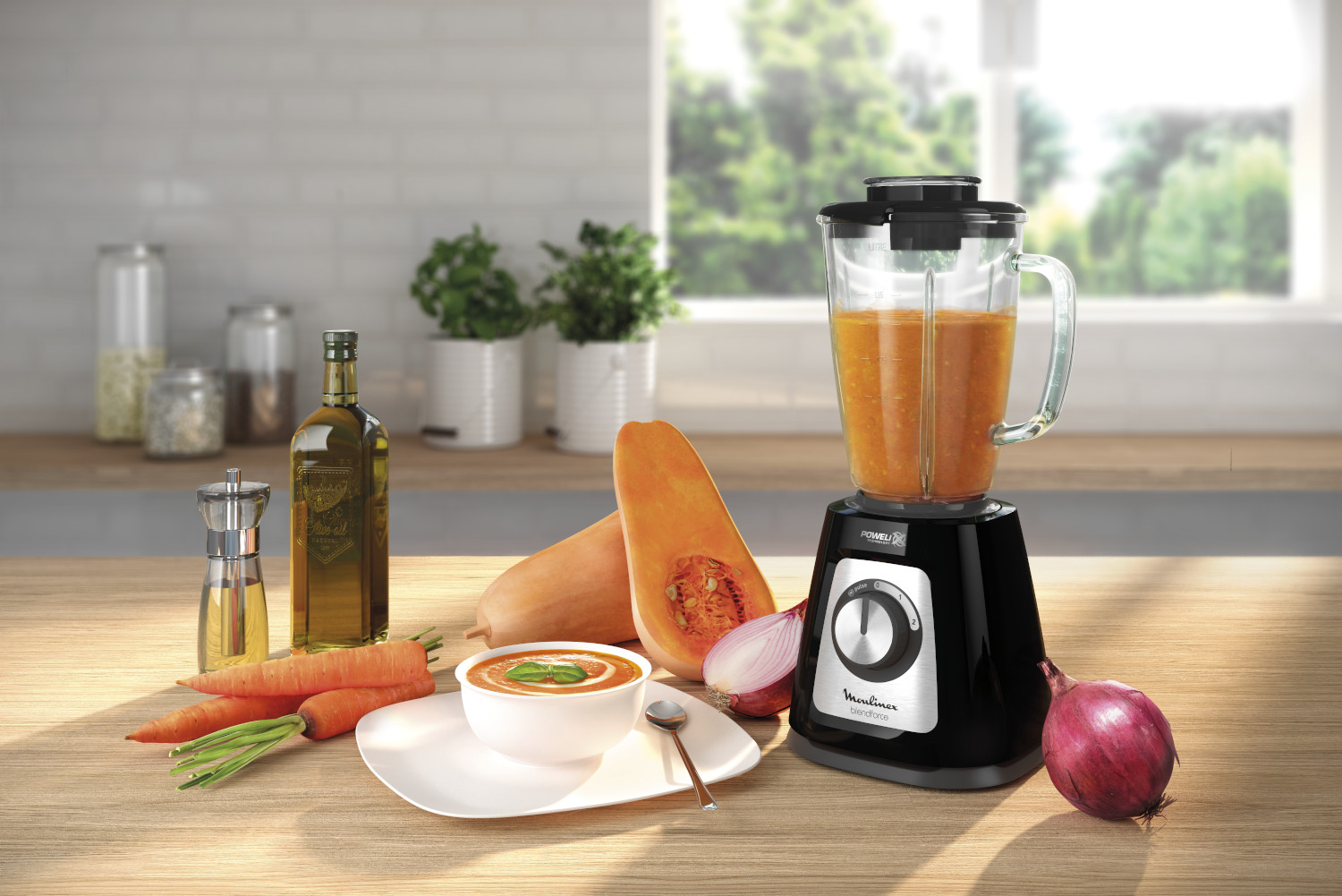 A blender with soup, vegetables, and oil on a wooden surface.