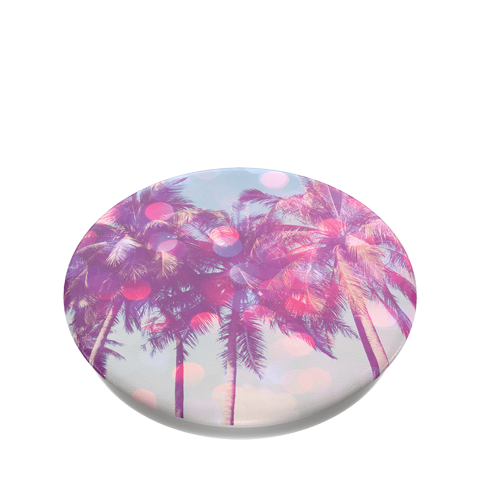 Un pop socket redondo con diseño de palmeras, con tonos rosa y morado sobre fondo celeste.