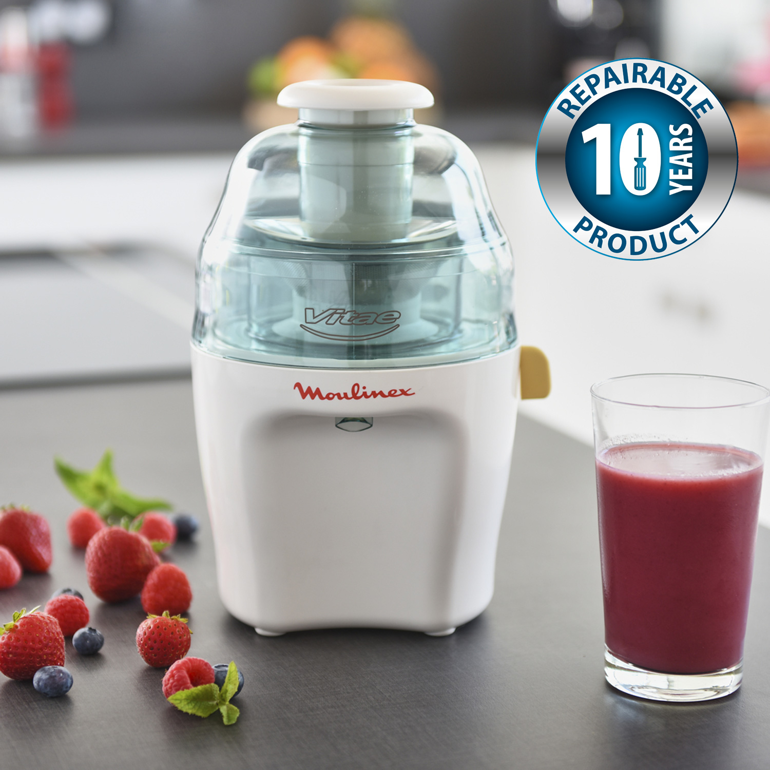 Una licuadora blanca con fruta, un vaso de jugo y una insignia de producto reparable.