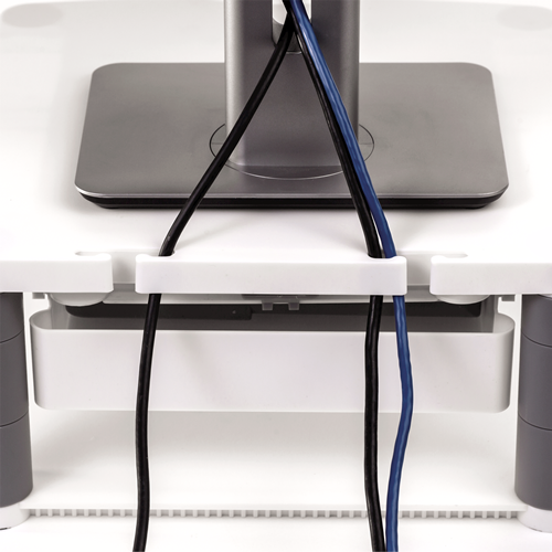 White desk with monitor stand and two cables, black and blue, organized by a white cable management system.