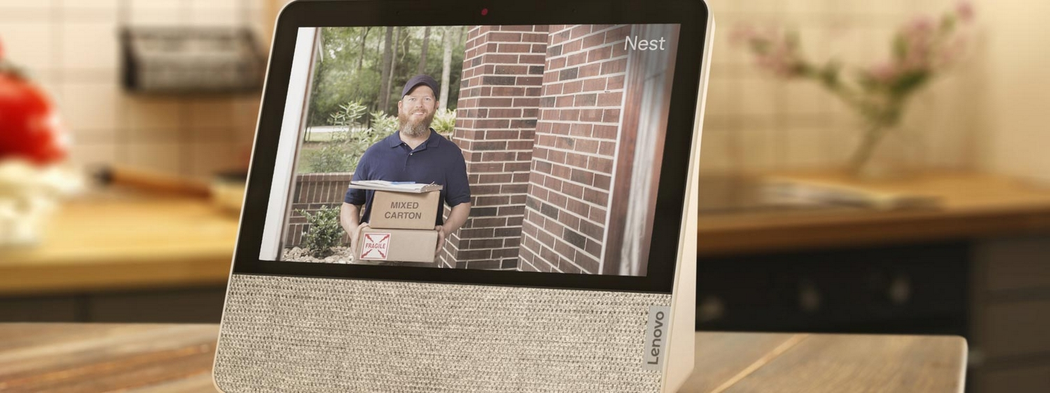 Pantalla inteligente Lenovo mostrando un hombre con cajas, una pared de ladrillos y vegetación.
