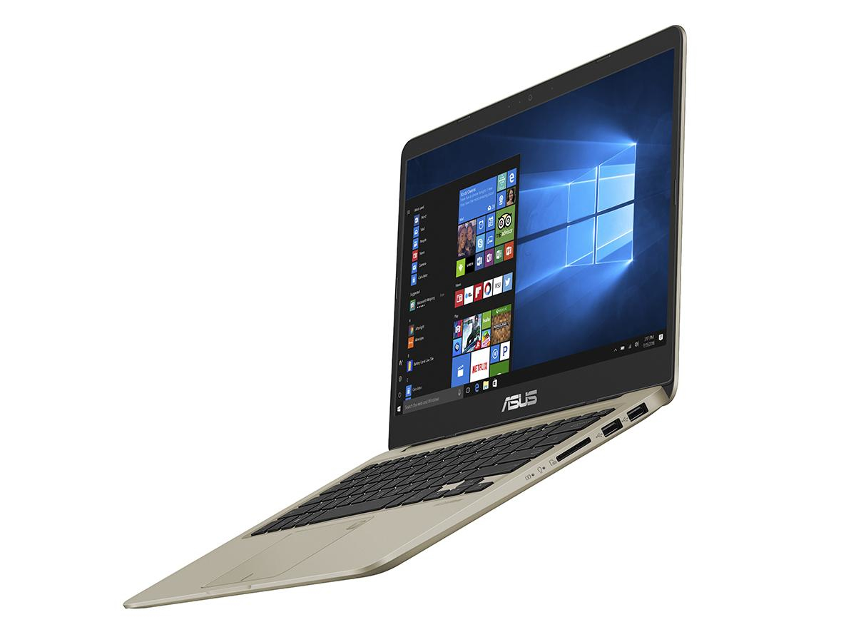 Ein offener, goldener ASUS Laptop mit beleuchtetem Windows-Desktop steht auf weißem Hintergrund.