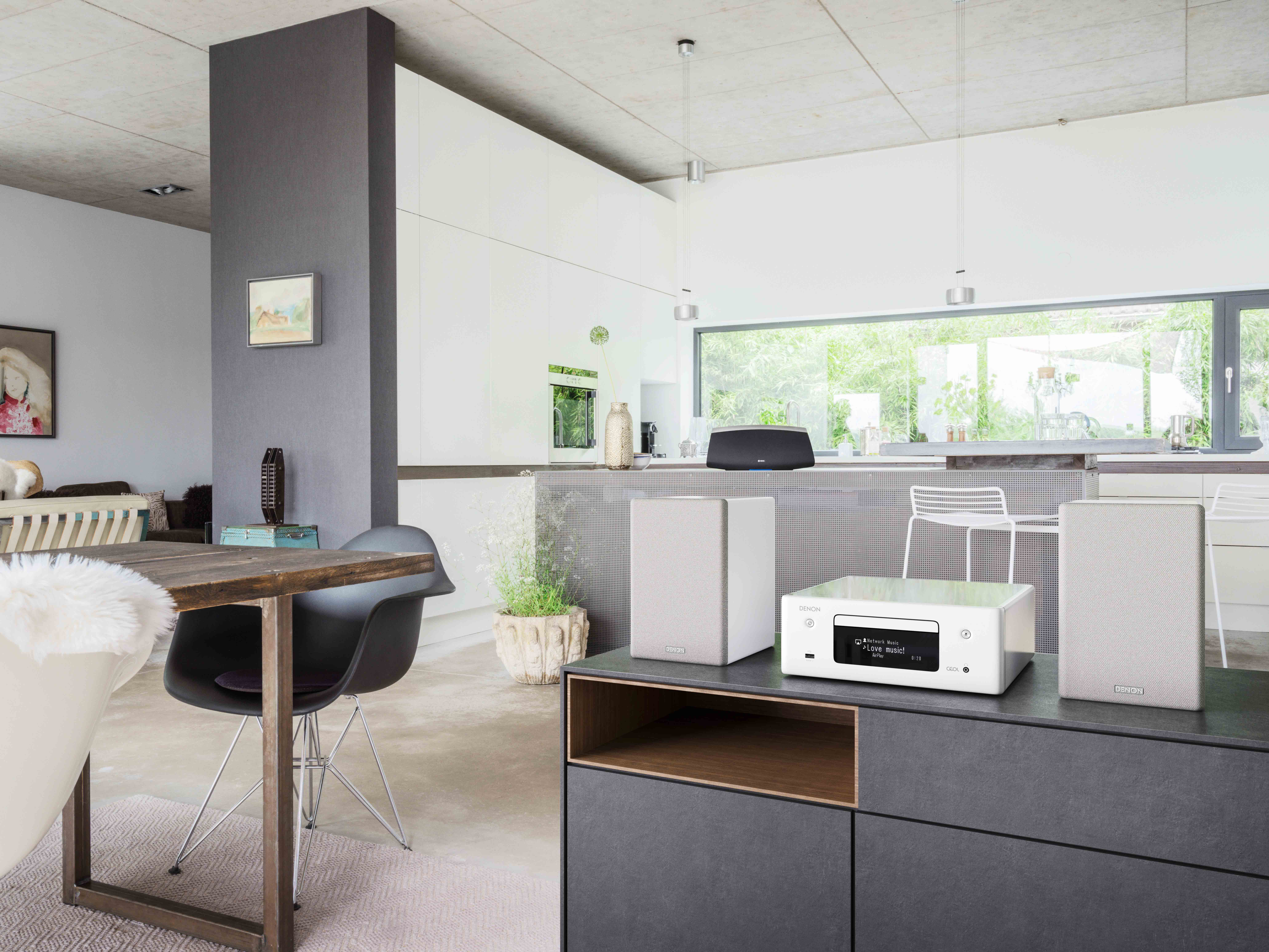 Küche mit weißen Schränken und einem schwarz-weißen Audiosystem.